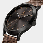 Elegant black and rose gold mesh wristwatch with minimalist dial and date display