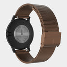 Close-up of a modern watch back with brown mesh stainless steel band and engraved clasp.