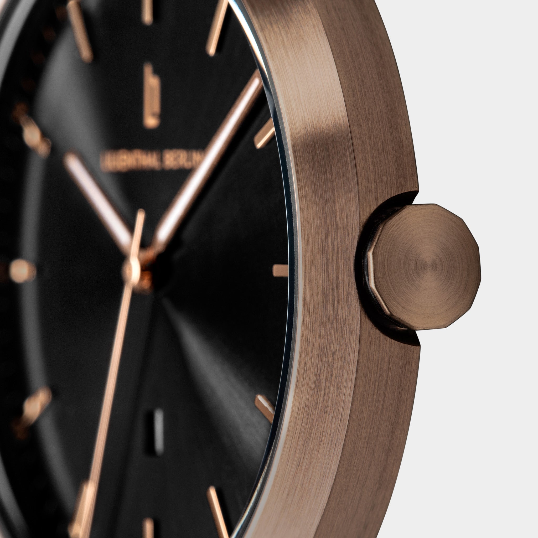 Close-up of a modern watch with a black face and rose gold case and details