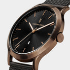 Elegant wristwatch with black dial, gold hour markers, mesh strap, and minimalist design