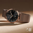 Elegant mesh band watch with black dial, date display, and German Design Award 2021 badge