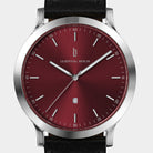 Minimalist wristwatch with a sunburst red dial, silver case, and black leather strap