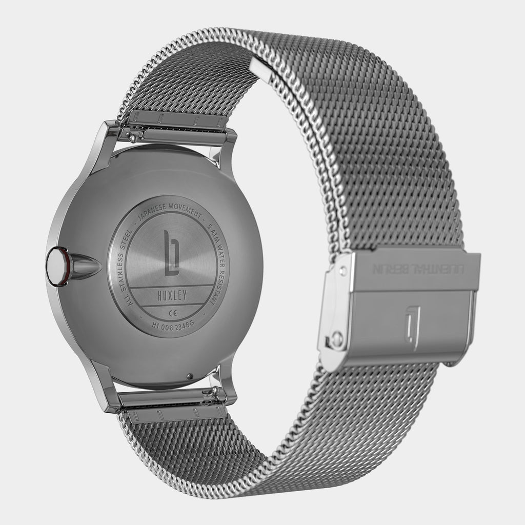 Close-up of stainless steel mesh watch band and case back with engraved details