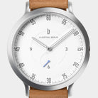 Minimalist silver watch with white dial, tan leather strap, and modern numeric markers.