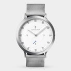 Minimalist silver mesh watch with white dial and black numerals on a light background