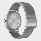 Stainless steel watch with mesh band, engraved case back, visible deployment clasp