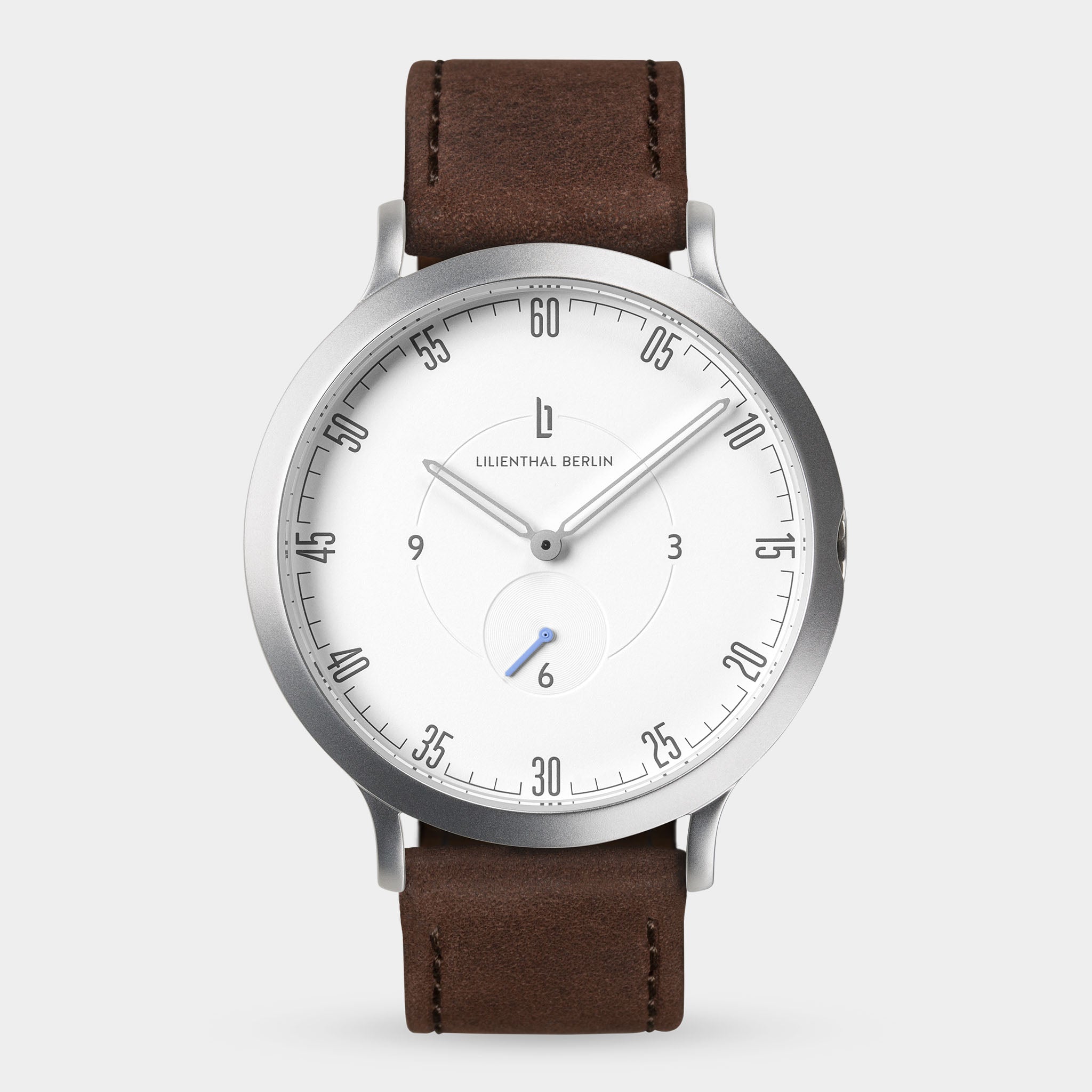 Minimalist silver watch with white dial, brown leather strap, and slim markers