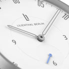 Minimalist analog watch face with silver hands, white dial, and subtle blue subdial hand