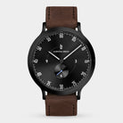 Minimalist black dial wristwatch with brown leather strap and subdial, modern design