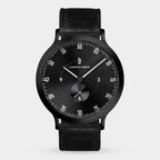 Black minimalist wristwatch with a black leather strap and sleek dial design