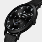 Minimalist black analog wristwatch with sunburst dial and black leather strap