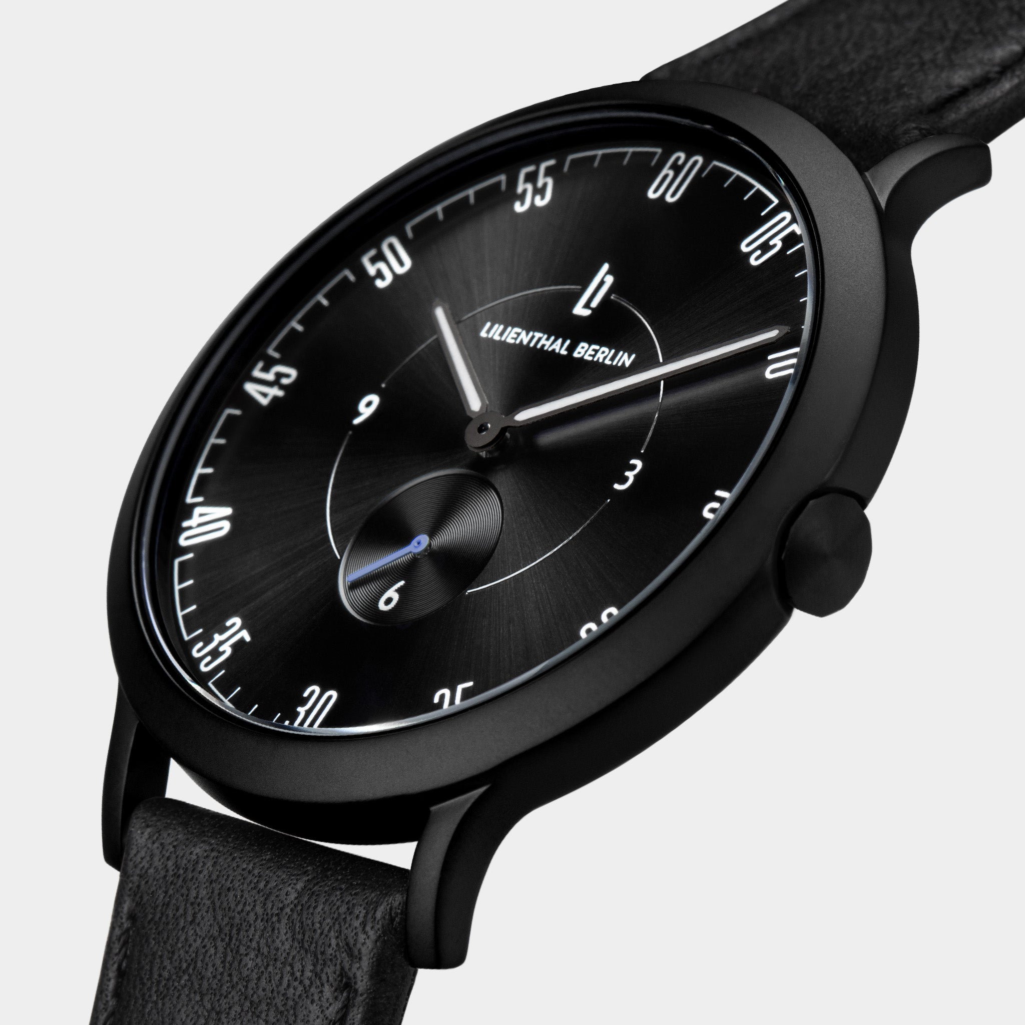Minimalist black analog wristwatch with sunburst dial and black leather strap