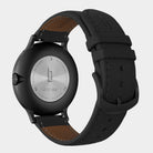 All-black stainless steel watch with black leather strap, caseback visible, engraved details