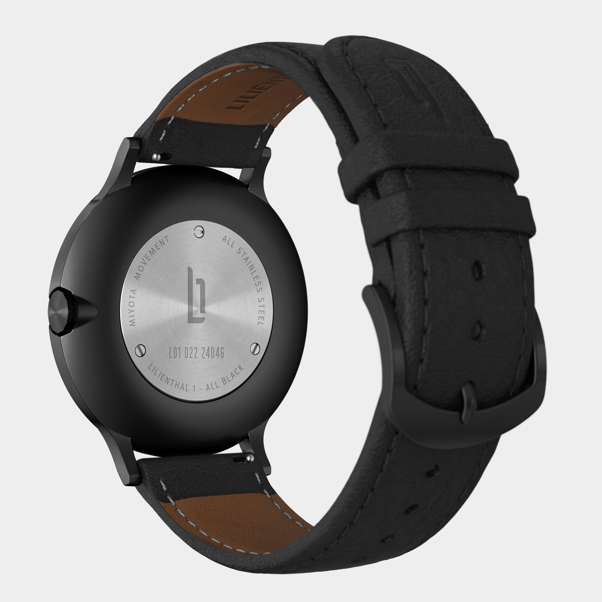 All-black stainless steel watch with black leather strap, caseback visible, engraved details