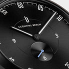 Close-up of a black minimalist watch face with white hands and Lilienthal Berlin logo.