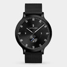 Minimalist black analog watch with mesh strap and sleek dial on white background