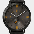 Black minimalist watch with sunburst dial, orange hour markers, and subdial at six o'clock