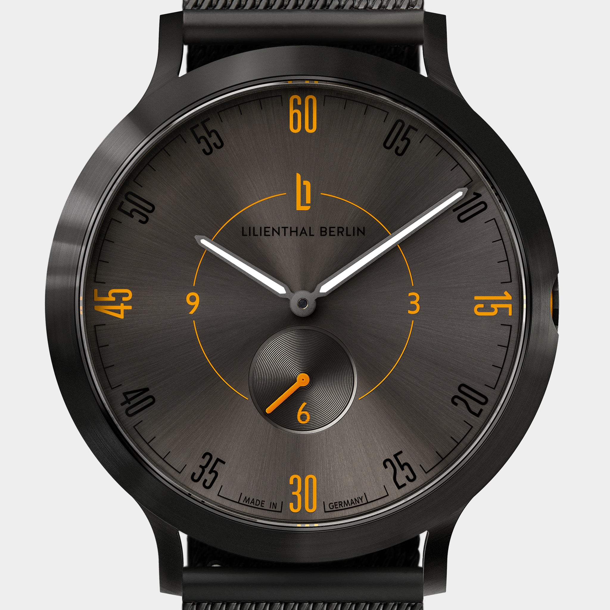 Black minimalist watch with sunburst dial, orange hour markers, and subdial at six o'clock