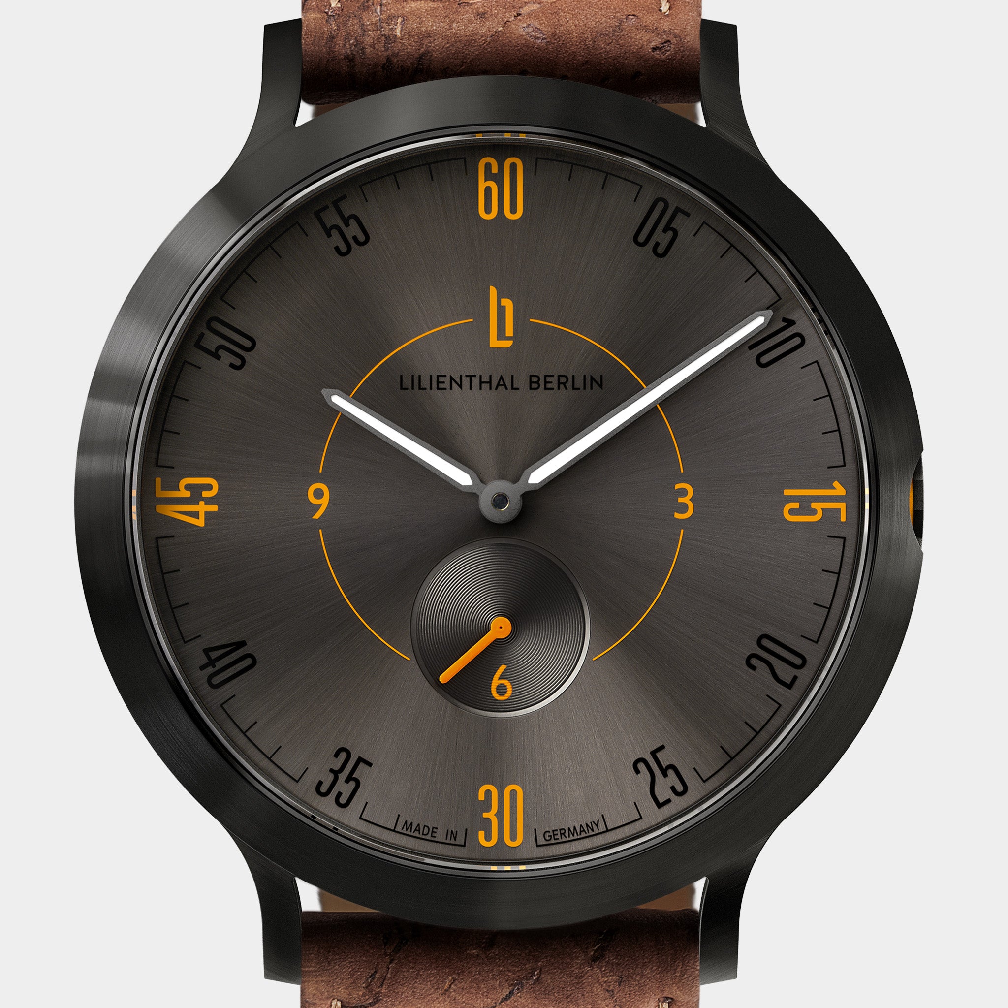Close-up of a modern wristwatch with black dial, yellow numerals, and brown leather strap