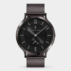 Minimalist black wristwatch with mesh band, round dial, and silver hour markers on white background.
