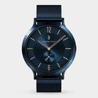 Minimalist blue wristwatch with mesh strap, gold hands, and slim indices on a white background.