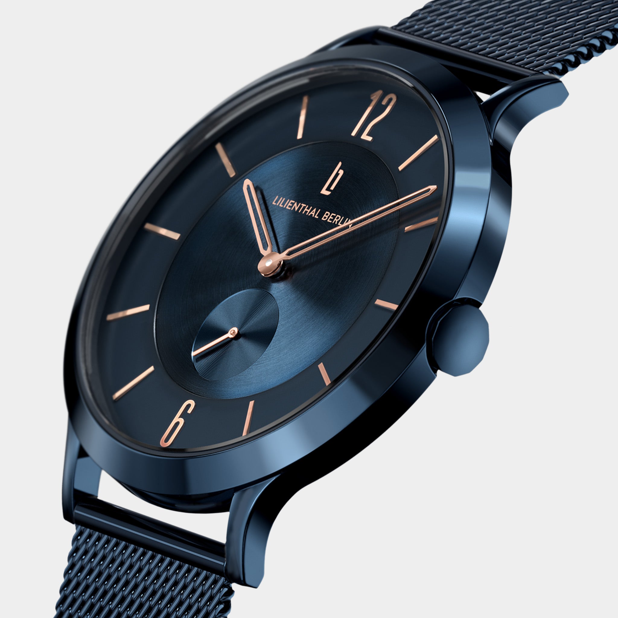 Blue minimalist wristwatch with mesh strap, rose gold accents, and sleek modern design.