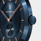 Close-up of a modern blue wristwatch with rose gold markers and a minimalist dial