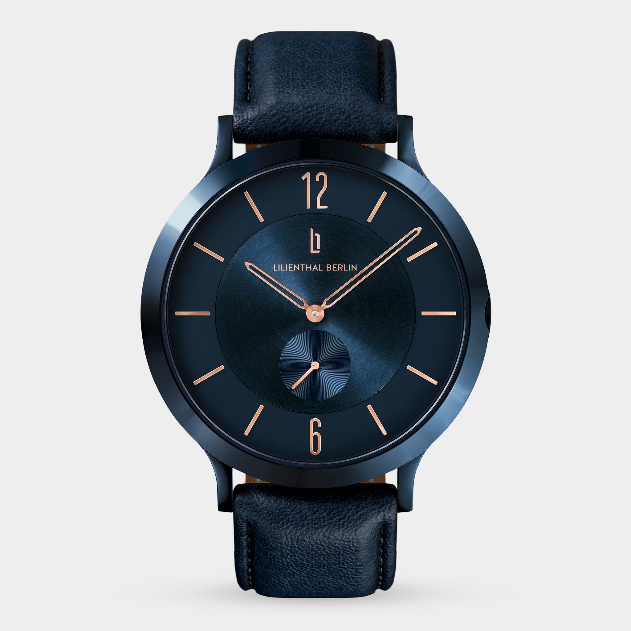 Elegant blue minimalist watch with rose gold hands and black leather strap on white background